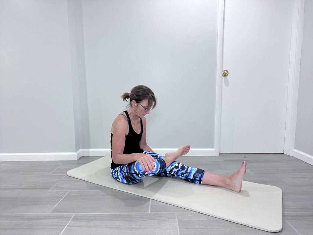 ankle stretch with right foot over left knee while pushing down on right knee.