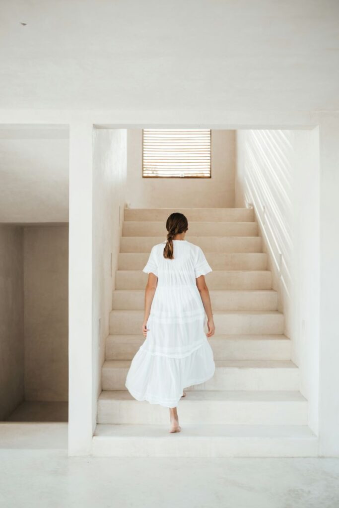 lady walking up stairs in white gown